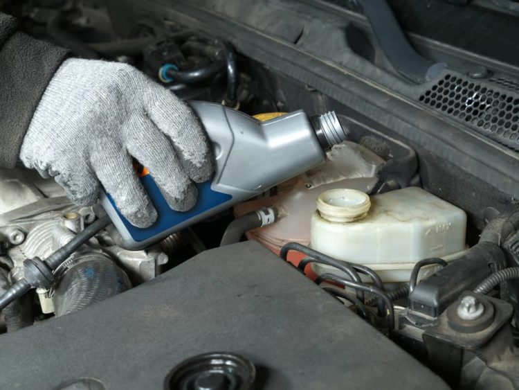 pouring brake fluid into car
